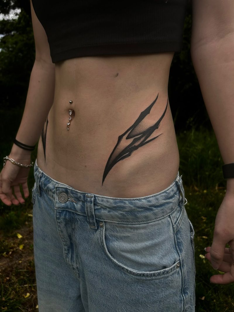 Abstract blackwork design with sharp shapes on the hip