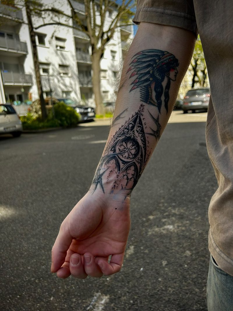 Gothic ornament with tracery window and dotwork on the forearm