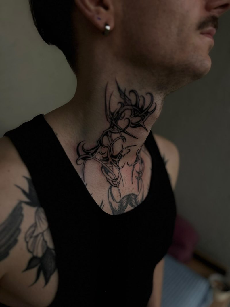 Ornamental fine line tattoo on the side of the neck