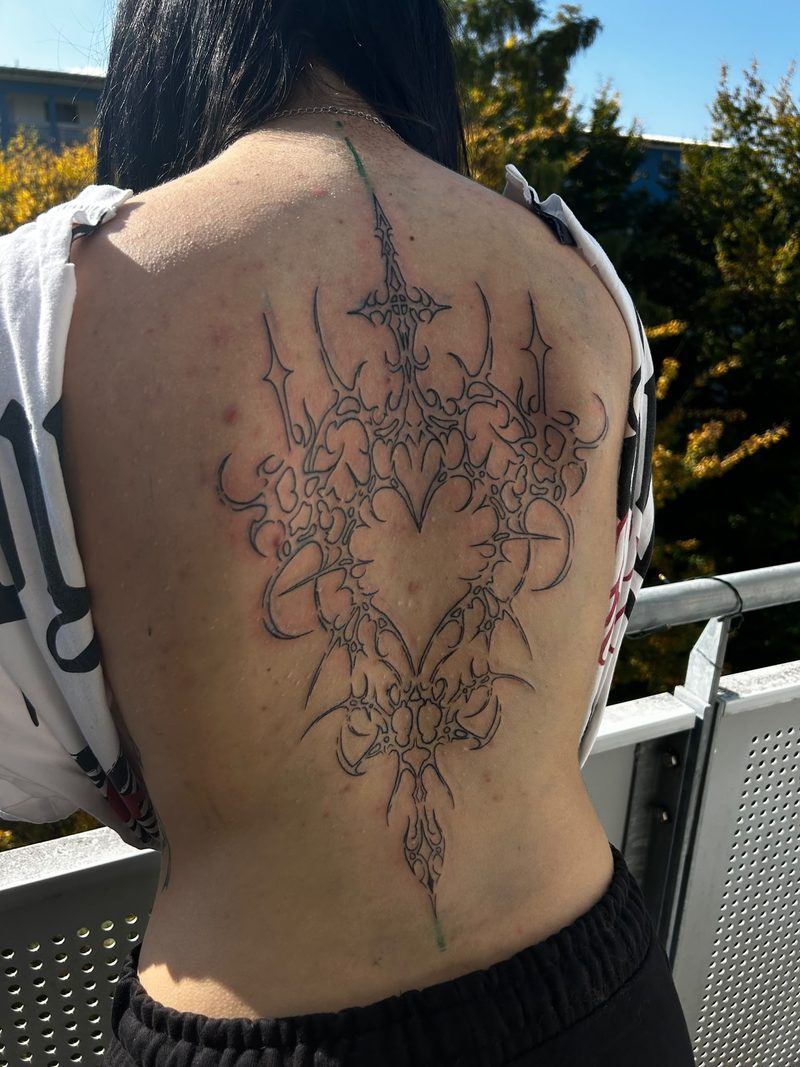 Large ornamental fine line tattoo across the entire back